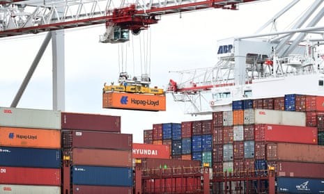 A crane removes containers from a ship.