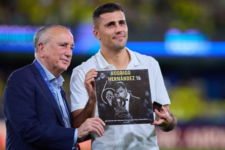 Rodri holds a placard of his Ballon d’Or achievement next to Fernando Roig