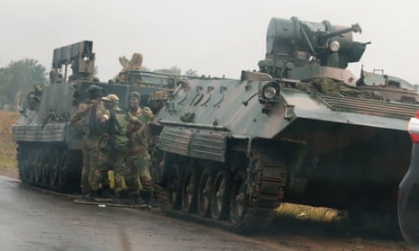Soldiers stand beside military vehicles just outside Harare