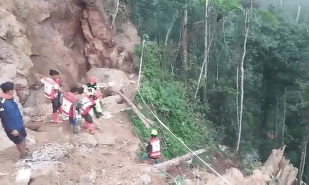 Rescue workers in Indonesia at the site of a landslide where gold miners were operating in North Sulawesi province. Photograph: Sutopo Purwo Nugroho/ Indonesia national disaster agency