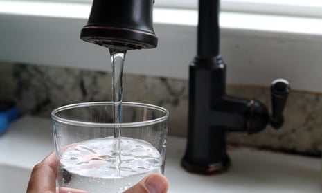 Water from a tap fills a glass.