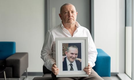 Tom Quigley holds a framed photograph of his older brother, David