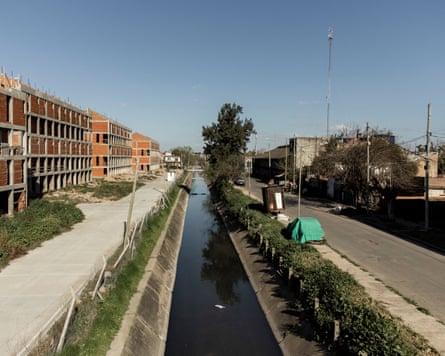 A river running through an urban area, with pavements and buildings on either side