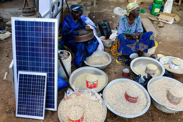 Solar panels are sold alongside food in a market in Burkina Faso.