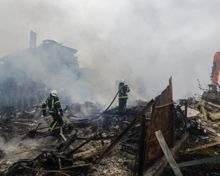 Ukrainian rescuers work at the site of a residential area struck by a rocket in an overnight strike in a village near Kyiv
