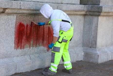 A worker removes anti-Russian slogans written at the site of the Soviet military cemetery in Warsaw.