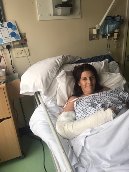 Jill lying in a hospital bed with her arm in a cast.
