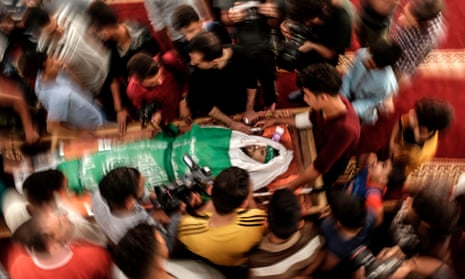 Palestinian mourners surround the body of Yazan al-Tubasi, killed during clashes in Gaza the previous day, during his funeral in Gaza City