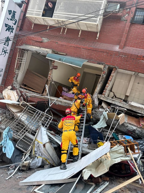 رجال الإطفاء يعملون في الموقع الذي انهار فيه مبنى في أعقاب الزلزال في مدينة هوالين بتايوان