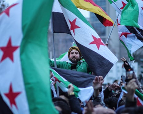 A crowd of people waving Syrian flags in Berlin