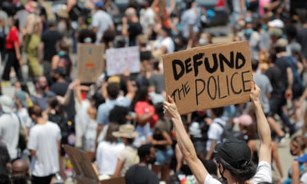 A demonstrator holds a sign reading ‘Defund the Police’ in New York.