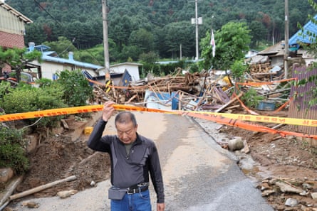 A resident leaves his house after torrential rain in Gapyeong, South Korea, on Monday.