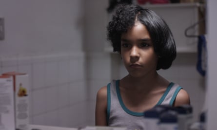 A film still showing a young boy with half straight, half curly afro hair.