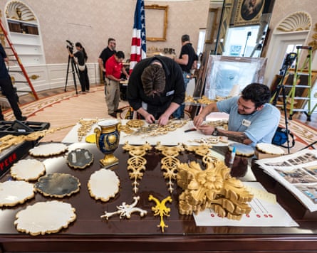 People in a fake, gilded Oval Office, with ladders.