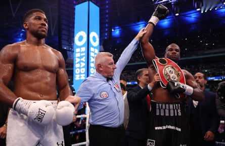 Daniel Dubois clutches the IBF heavyweight championship belt as his arm is raised in triumph as he is declared the victor. Photograph: Mark Robinson/Matchroom Boxing