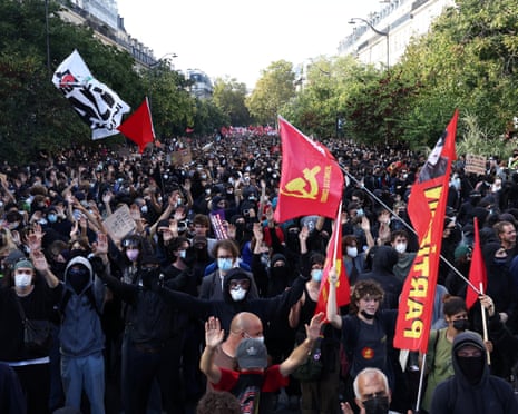 Protesters hold placards and flags during a demonstration by high school and university students, in Paris, France.