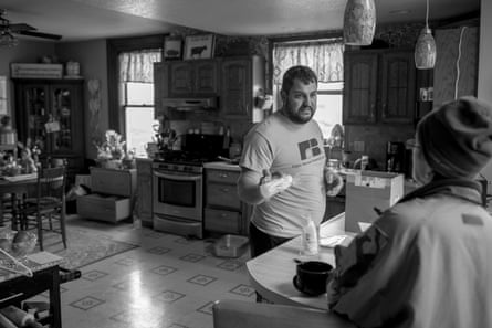 A man talks to a woman in the kitchen of their home.