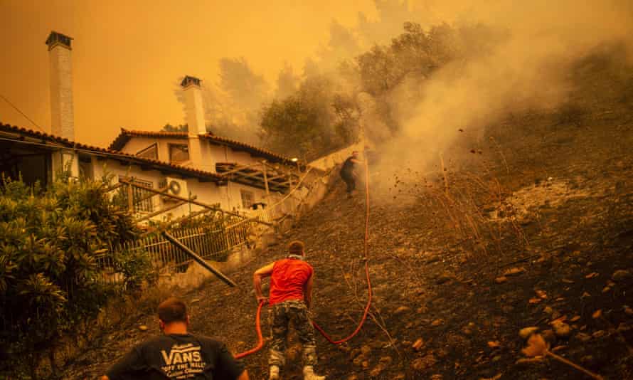 Residents fight a forest fire in the village of Gouves in Evia.