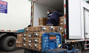 Workers transport frozen meat products on a truck at a wholesale market for frozen food, following the coronavirus outbreak in Beijing, China 26 November 2020.