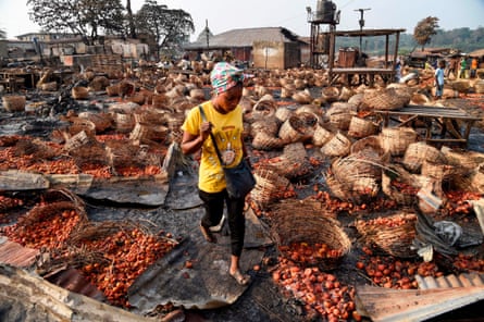 A lady walks among baskets full of tomatoes vandalised after deadly ethnic clashes between the northern Fulani and southern Yoruba traders in Ibadan, south-west Nigeria in 2021.
