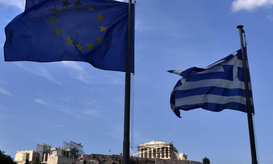 The EU and Greek flags fly together in front of the Acropolis in central Athens.
