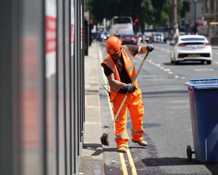 A worker sweeps the street outside a construction site