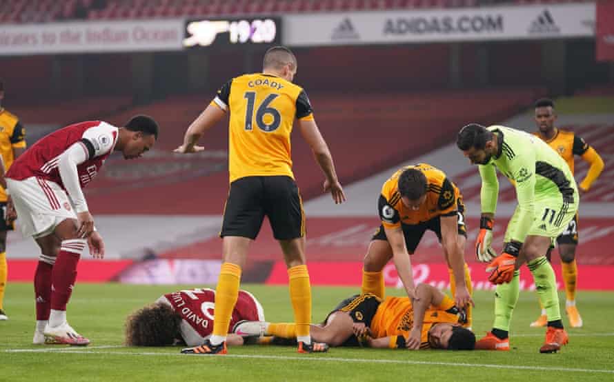 Raul Jimenez of Wolverhampton Wanderers and David Luiz of Arsenal receive help after a head collision.
