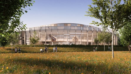 a curved glass and metal-framed structure set in a green space with trees and a nearby footpath through a wildflower meadow, along which people are walking.