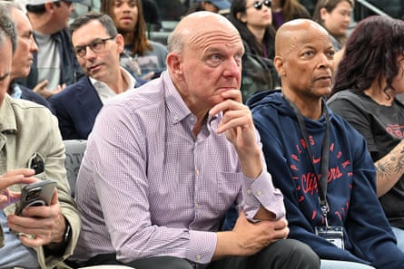 Man rests hand on chin while seated at a game with other crowd members