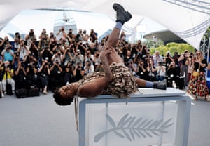Jonathan Guilherme lies back on a desk etched with the Palme d'Or in front of photographers at the Cannes film festival
