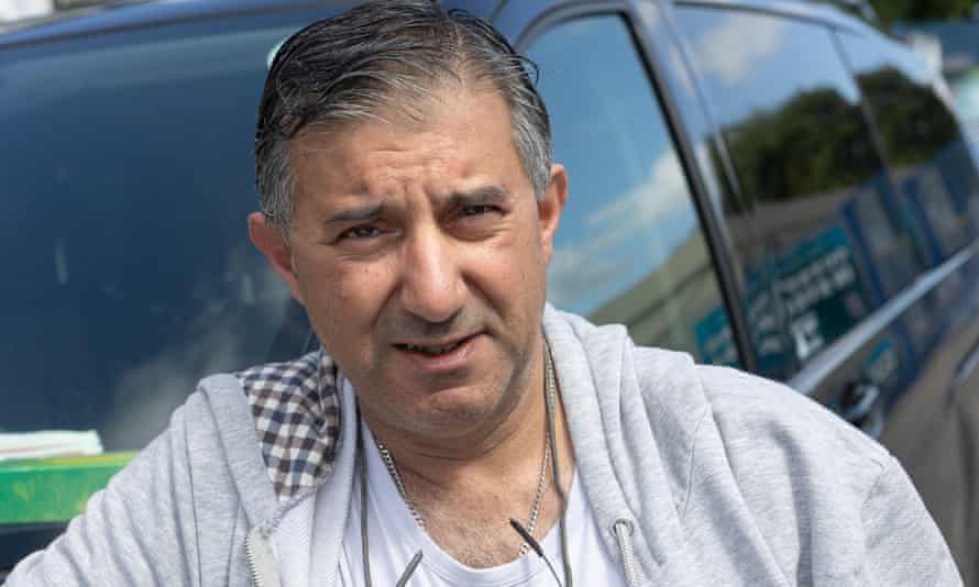 Nader Awaad stands next to his taxi.