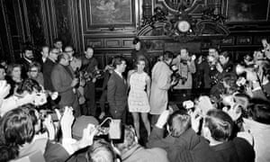 Original caption: Film actress Raquel Welch, wearing a crocheted mini dress and her manager, Patrick Curtis, are besieged by photographers as they enter the room in Paris for their wedding ceremony, 14 February 1967. The ceremony was delayed for 15 minutes while police and city officials tussled with the photographers who had been ordered out of the ceremonial room