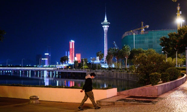 A man walks along the waterfront in Macau