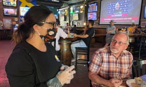 Restaurant owner Sandy Drown talks with a customer, Tim Schmidt, at the Happy Viking Sports Pub.
