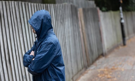 A scam victim who wants to remain anonymous wearing a rain jacket with hood pulled up.