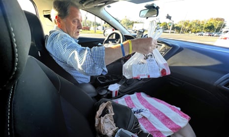 Nevin Overmiller, 78, examines an order of KFC while delivering the meal for Uber Eats on 5 January 2021 in Palm Harbor, Florida to supplement his retirement income.