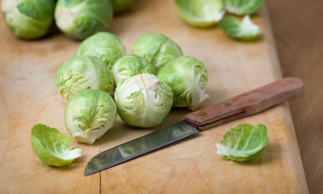 Brussels sprouts and a knife on a chopping board