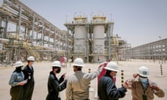 A group of people in hard hats in a large natural gas plant in Saudi Arabia
