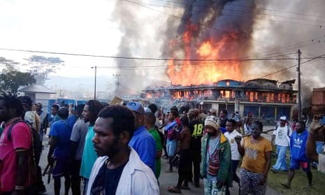 Protesters in West Papua with burning buildings