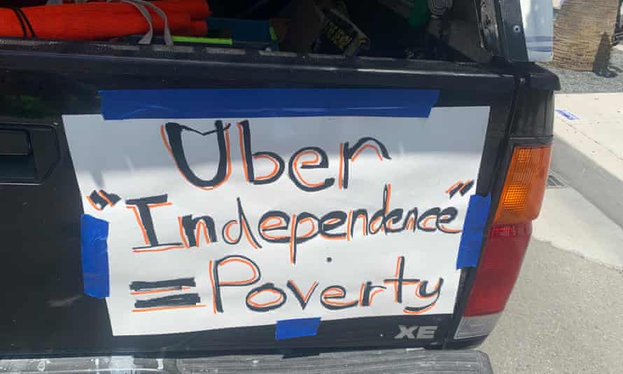 a truck with a sign that says "Uber 'independence' = poverty"