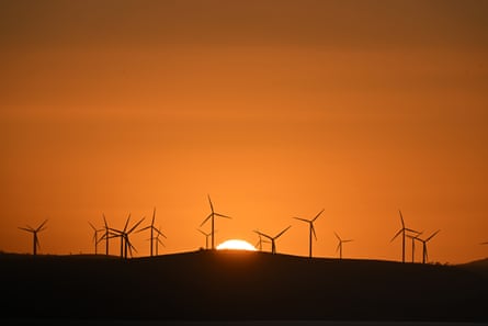 The sun rises over wind turbines at the Capital Wind Farm, east of Canberra