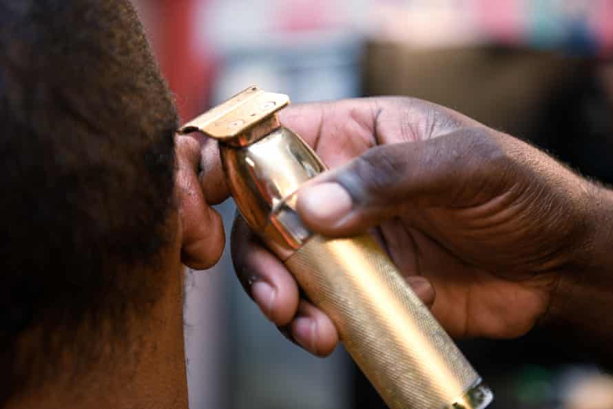 Julian Turner, 36, gets his hair cut at Daddy's Choice Barber Shop.  Shop owner Reverend Kenneth B Thomas Sr. encourages his customers to get vaccinated.