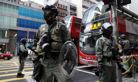 Police stand guard in front of a bus stop in Hong Kong.