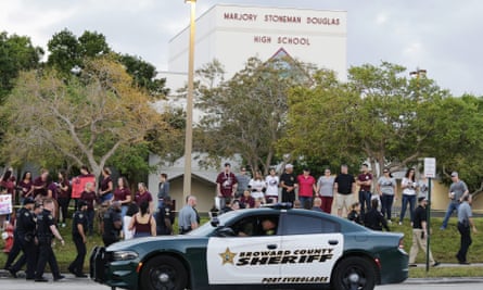 A police car drives by Marjory Stoneman Douglas high school in Parkland, Florida, as students return to class.