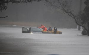 A State Emergency Service swift water rescue boat attends to Brian Russell’s car after rescuing him