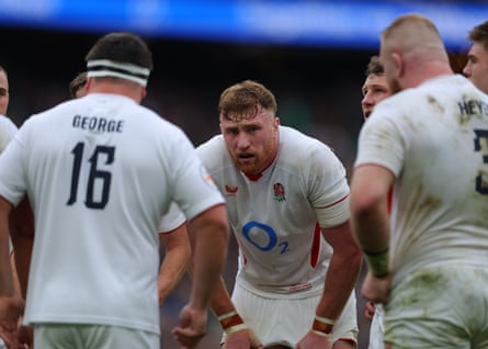 Ollie Chessum looks done a huddle of his England teammates