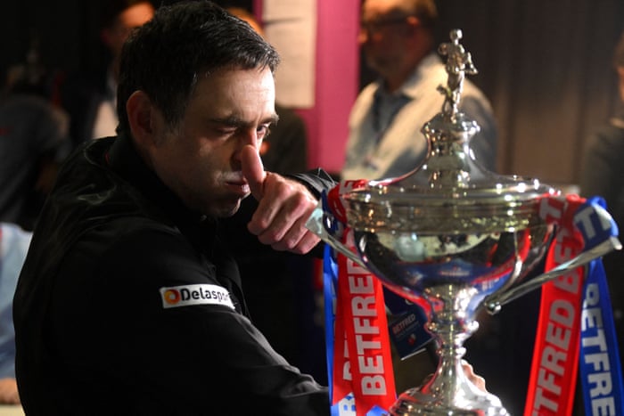 Ronnie O’Sullivan gestures as he sits with the trophy during the press conference following his record-equalling triumph.