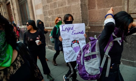 A woman holds a sign for Ingrid Escamilla as women demonstrate outside the national palace in Mexico City on 14 February.