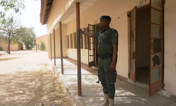 A police officer stands guard at the premises of Government Girls’ Science and Technical College, where 110 girls were kidnapped by Boko Haram.