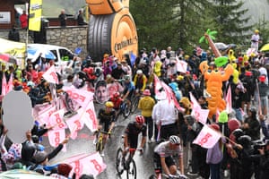 Julian Alaphilippe of Team Tudor Pro Cycling (centre) competes climbing to the La Plagne while fans cheer him on.